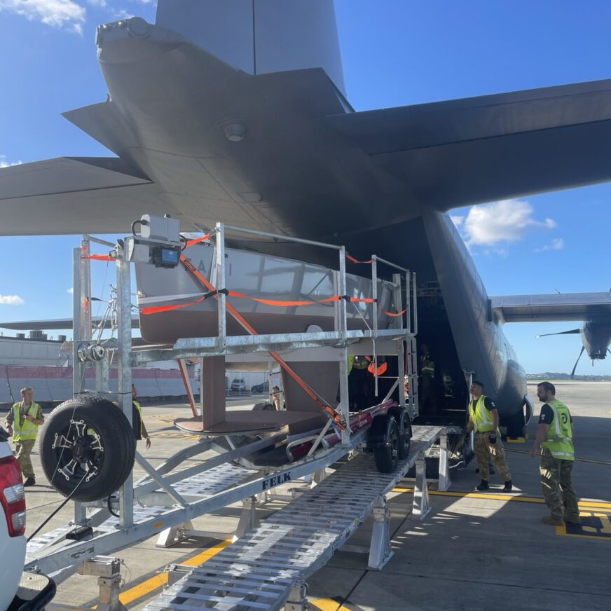 A Bluebottle USV is loaded on to a military plane on a trailer.